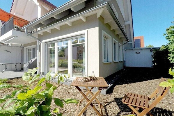 Il s’agit d’une propriété résidentielle dotée d’un balcon, d’une porte-fenêtre coulissante, d’une petite table en bois et d’une chaise en bois.