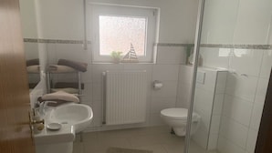 Een badkamer met een wastafel, toilet en douche.