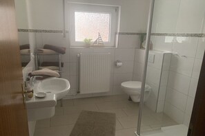 A bathroom with a sink, toilet, and shower. - Holiday apartment with 1 bedroom (Maasholm)