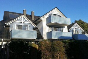 A two-story house with a gabled roof, dormer windows, and a balcony on the upper floor. - Holiday apartment with 2 bedrooms (Zingst)