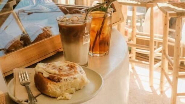 Una barra de café con un pastel, una bebida y un menú.