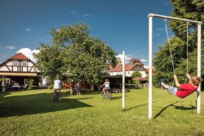 Un parque infantil con columpios y una pista para bicicletas.