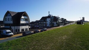 A residential area with modern houses, a road, and parked cars. - Apartment in Huisduinen with swimming pool (Huisduinen)