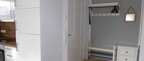 A compact kitchen with white cabinets, a built-in oven, and a small countertop.