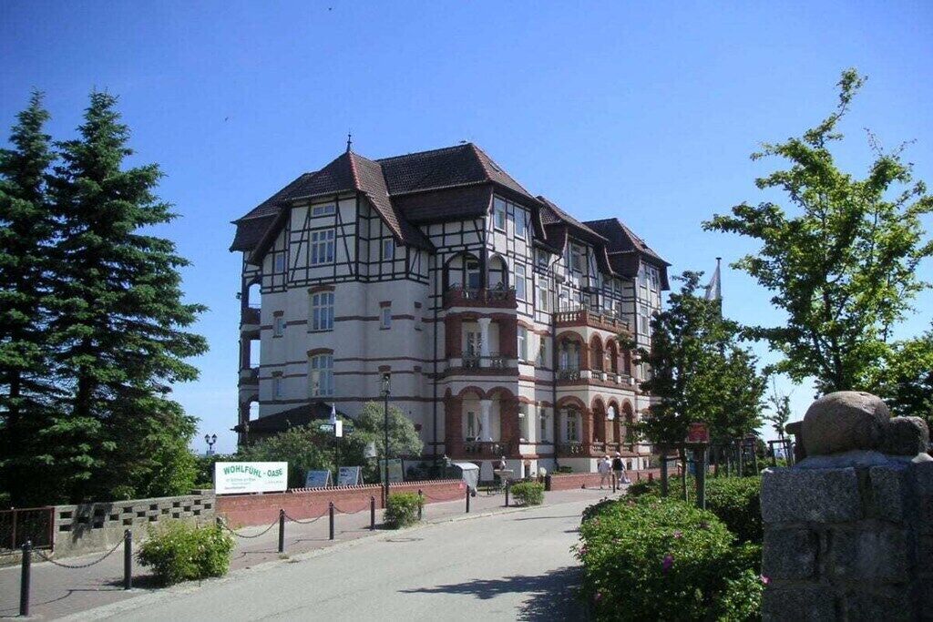 A traditional half-timbered building with a prominent entrance and a signboard.
