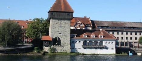 A historic building with a tower and a large white building with multiple windows.