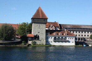 Un edificio storico con una torre e un ampio palazzo bianco con numerose finestre.