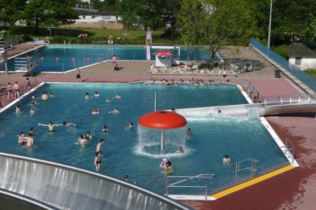 En swimmingpool med flere baner, en vandrutsjebane og en redningsplatform.