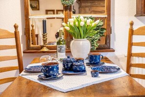A dining table with blue tea sets and a vase of white tulips. - Holiday apartment with 1 bedroom (Born am Darß)