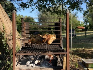 Ein Grill mit einem großen Stück Fleisch, das draußen gegrillt wird.