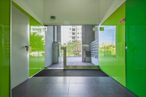 A hallway with green walls and a glass door leading to an outdoor area. - Spacious apartment with balcony • Porto • 2 bedrooms (Porto)