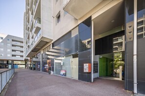 A modern building with a glass facade, a visible fire alarm, and a pedestrian pathway. - Spacious apartment with balcony • Porto • 2 bedrooms (Porto)