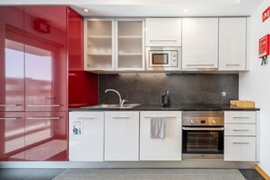 A modern kitchen with stainless steel appliances, a built-in oven, and a microwave. - Spacious apartment with balcony • Porto • 2 bedrooms (Porto)
