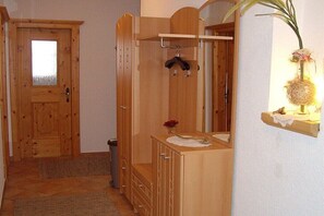 A wooden bathroom with a sink, mirror, and a hanging coat rack. - Holiday apartment with 2 bedrooms (Schwendau\/Mayrhofen)