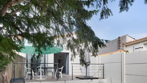 Un patio con mobiliario exterior, una mesa y una silla.