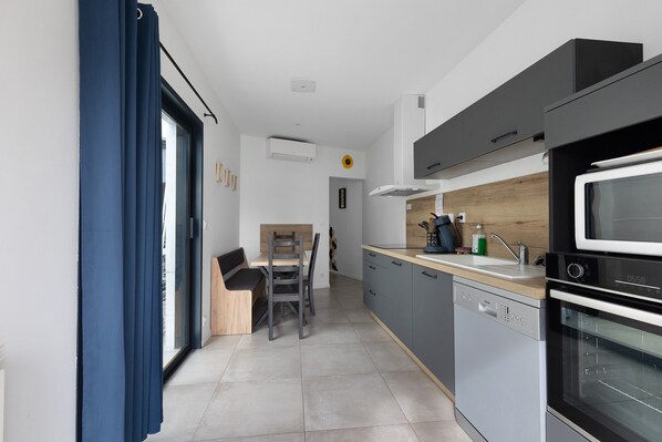 A modern kitchen with a built-in oven, microwave, and dishwasher.
