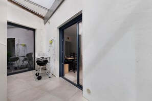 A narrow outdoor space with a barbecue grill, a folding chair, and a table with chairs. - House with Garden South Beach Near Fouras Center (Fouras)