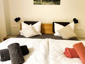 Quarto de hotel com cama de casal, duas mesas de cabeceira e um quadro na parede.