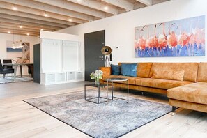 Ein modernes Wohnzimmer mit einer Couch, einem Couchtisch und Kunstwerken an der Wand.