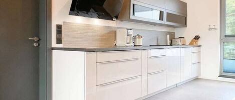 Eine moderne Küche mit Backofen, Mikrowelle und Edelstahlmöbeln.