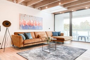 Ein modernes Wohnzimmer mit einer Couch, einem Couchtisch und einem Gemälde an der Wand.