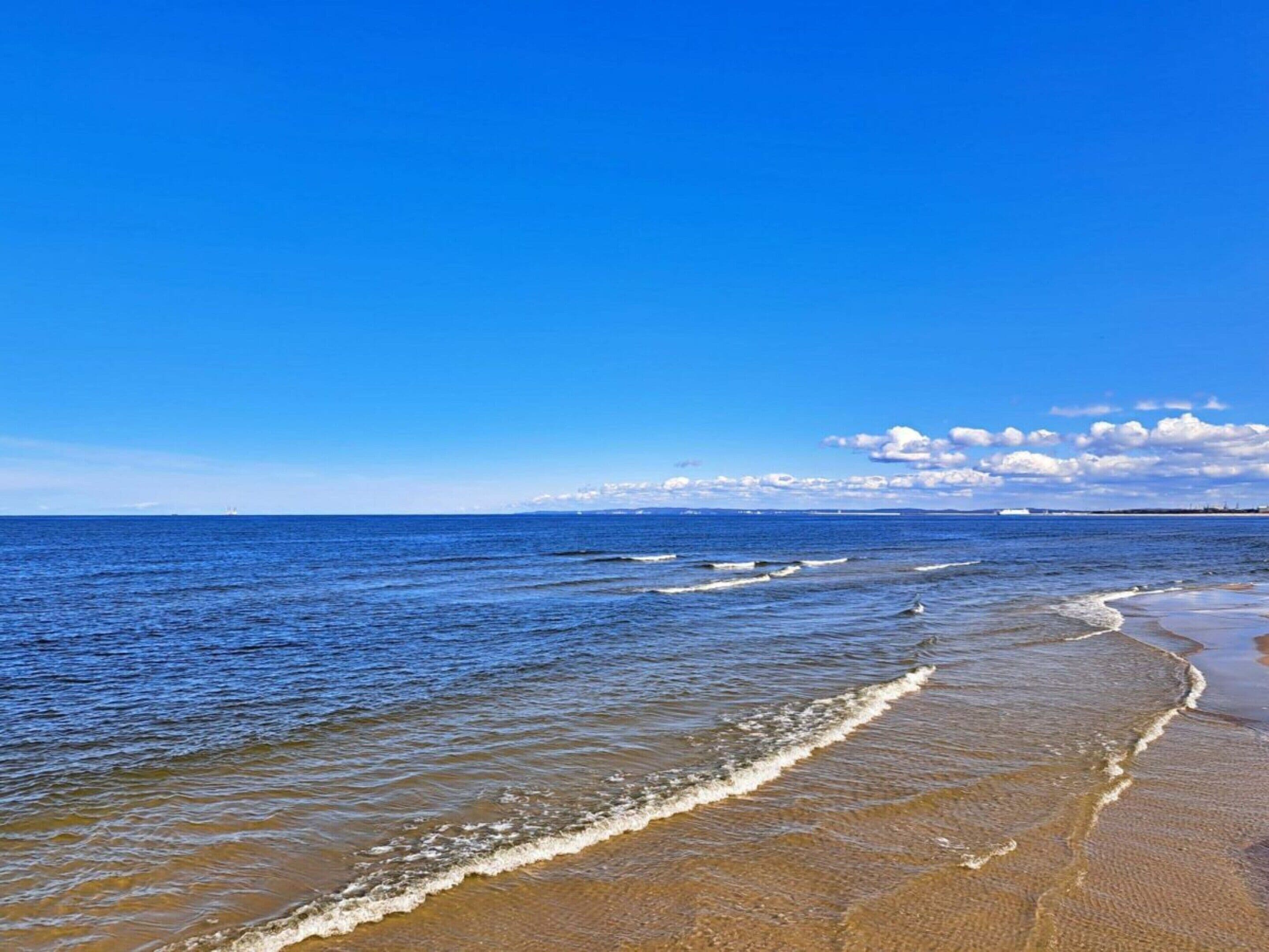 Una playa con aguas azul turquesa y una orilla arenosa.