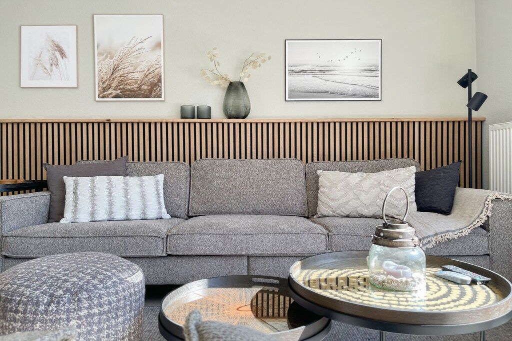 A modern living room with a grey sofa, a round coffee table, and a side table.