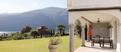 A property with a patio area, outdoor seating, and a view of the sea and mountains.