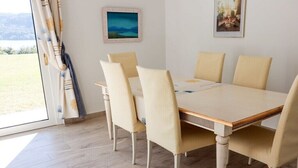 A dining area with a table and chairs, a view of the outdoors, and artwork on the walls. - Casa dell' Orso || Morcote (Morcote)