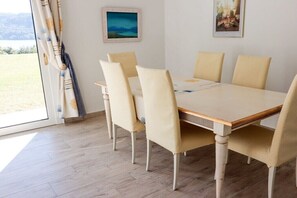 A dining area with a table and chairs, a view of the outdoors, and artwork on the walls. - Casa dell' Orso || Morcote (Morcote)