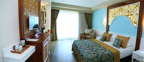 A hotel room with a bed, bedside table, and a mirror. - J'adore Deluxe Hotel & Spa All Inclusive (Manavgat)