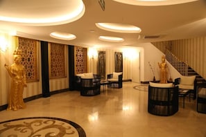 A lobby with a staircase, golden statues, and modern furniture. - J'adore Deluxe Hotel & Spa All Inclusive (Manavgat)