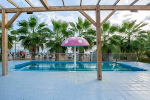 A swimming pool with a wooden pergola and a pink umbrella, surrounded by palm trees. - J'adore Deluxe Hotel & Spa All Inclusive (Manavgat)