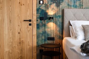 Ein Schlafzimmer mit einem Holfischschrank, einem Bett mit weißer Bettwäsche und einem kleinen runden Tisch.