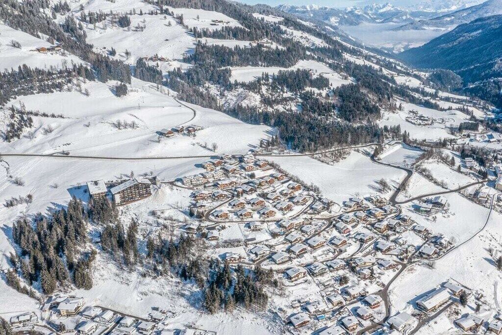 Una vista aerea di un villaggio innevato con case ed edifici.