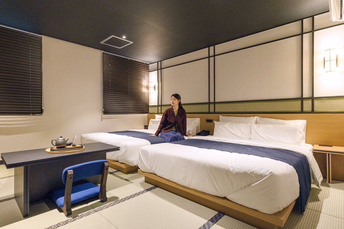 Una habitación de hotel con dos camas, un escritorio y una silla.