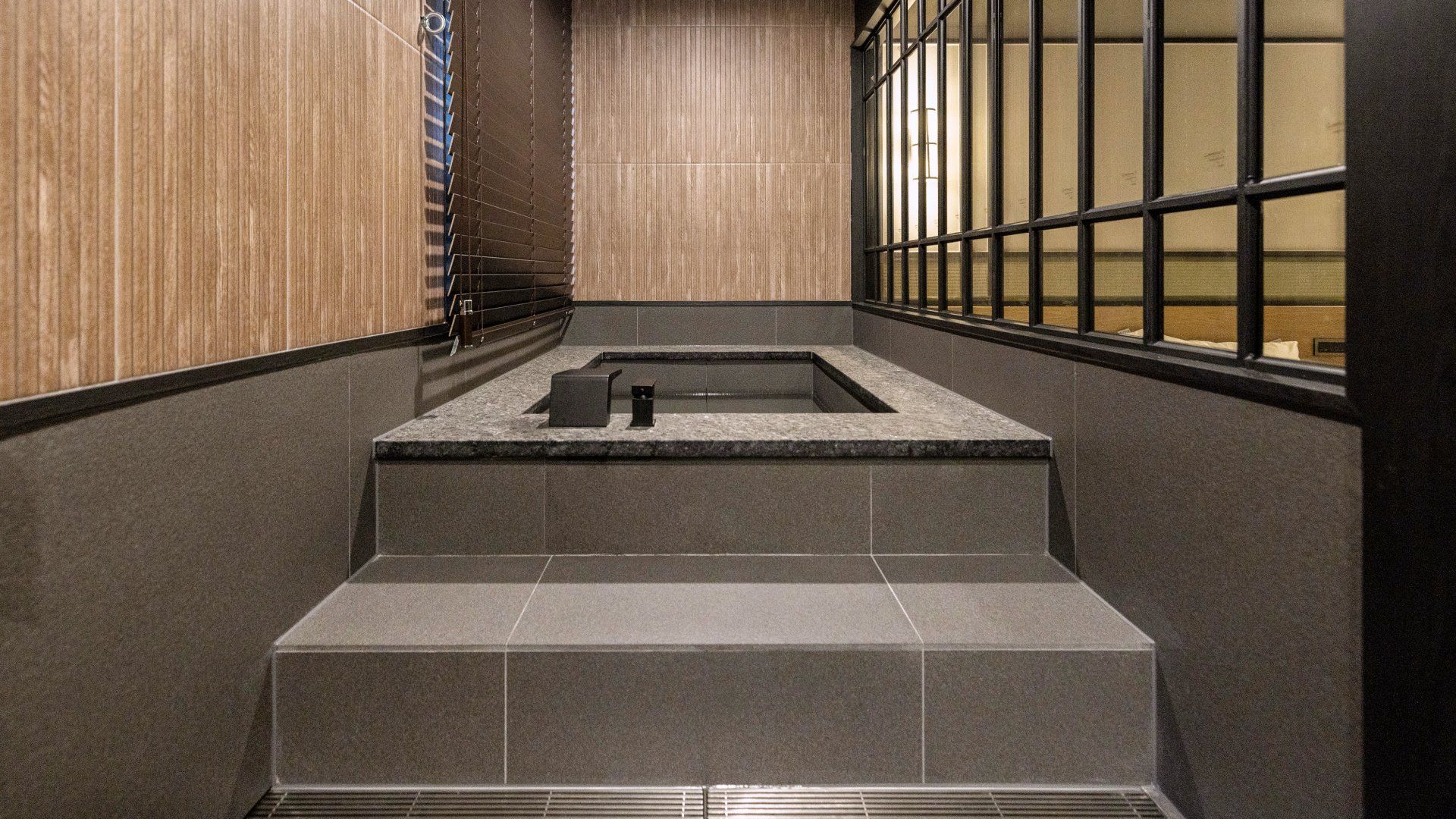Un baño moderno con lavabo de piedra, inodoro y zona de ducha.