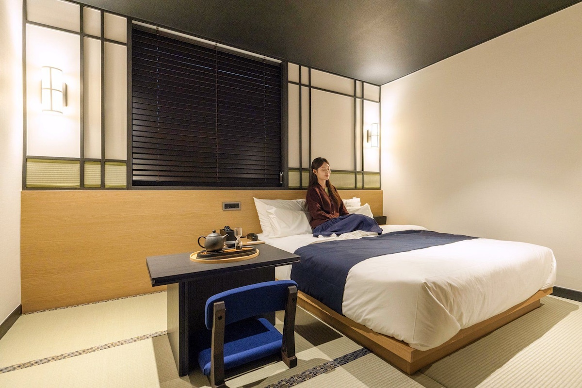 Una habitación de hotel con una cama, un escritorio y una silla.