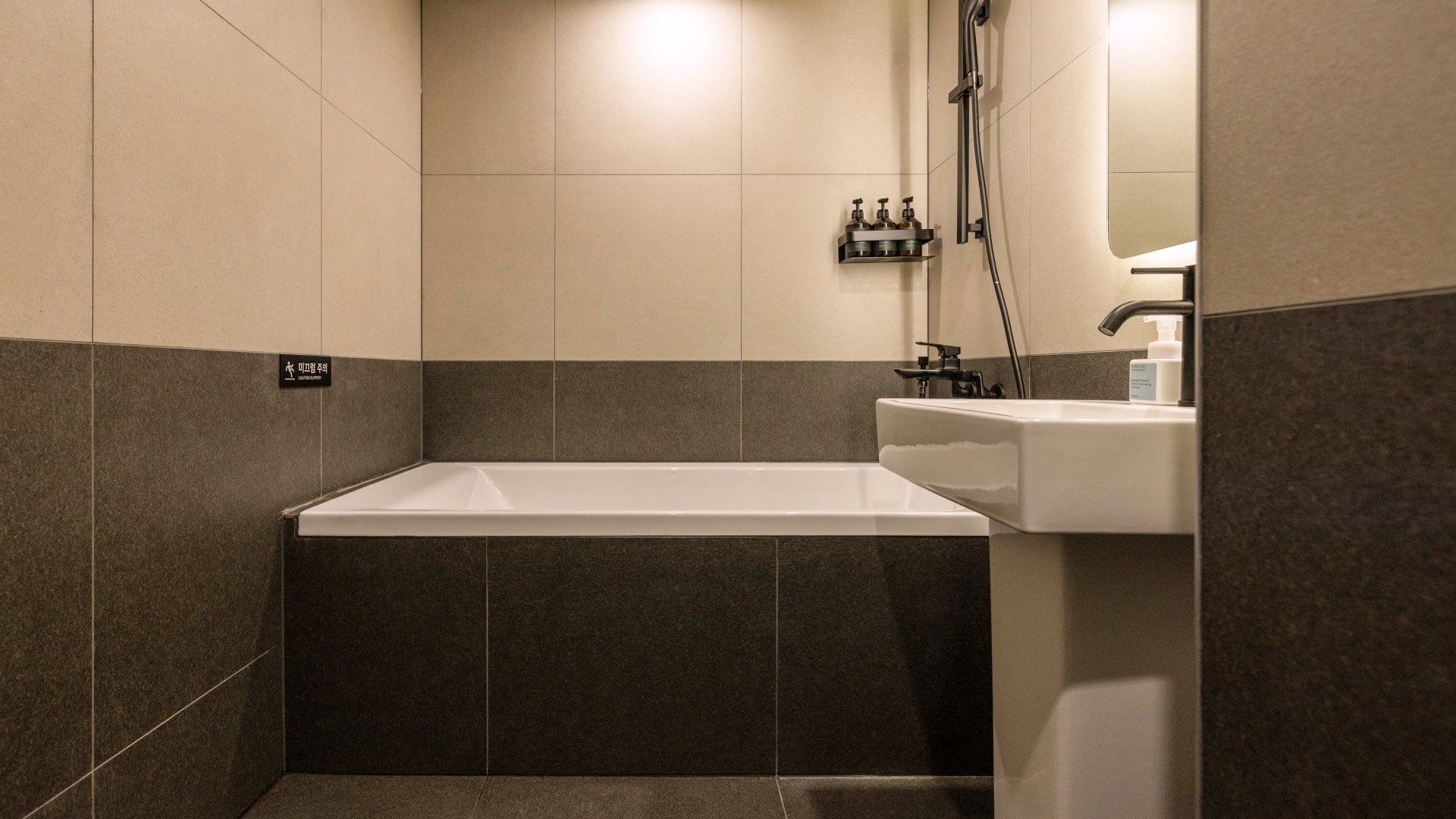 A bathroom with a bathtub, a sink, and a shower area.