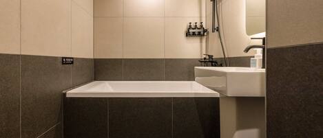 A bathroom with a bathtub, a sink, and a shower area.