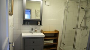 A bathroom with a sink, mirror, and shower. - Holiday apartment with 1 bedroom (Milda, Deutschland)