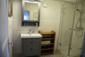 Une salle de bain avec un lavabo, un miroir et une douche.