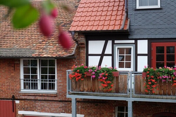 Un bâtiment traditionnel avec un toit en tuiles, des balustrades en bois et des jardinières.