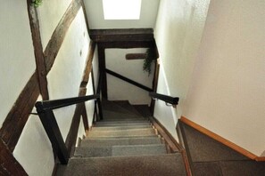 Eine Treppe mit Holzwertlauf und einem kleinen Fenster am oberen Ende.