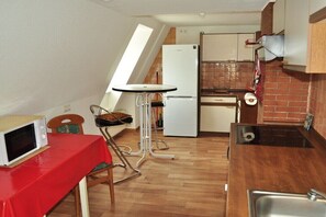 Eine kompakte Küche mit einer Mikrowelle, einem kleinen Esstisch und einem Kühlschrank.