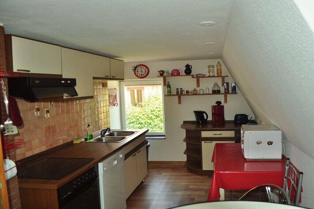 Una cocina funcional con lavavajillas, pileta y ventana que proporciona luz natural.
