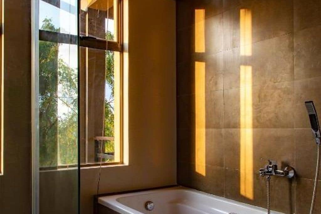 Un baño moderno con bañera, ventana y ducha.