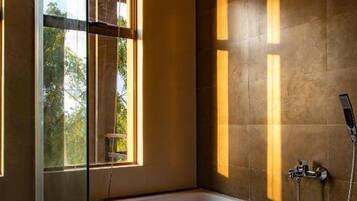 Un baño moderno con bañera, ventana y ducha.