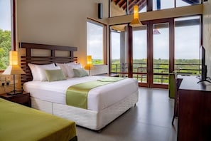 Una habitación de hotel con una cama grande, un escritorio y un balcón con vistas.