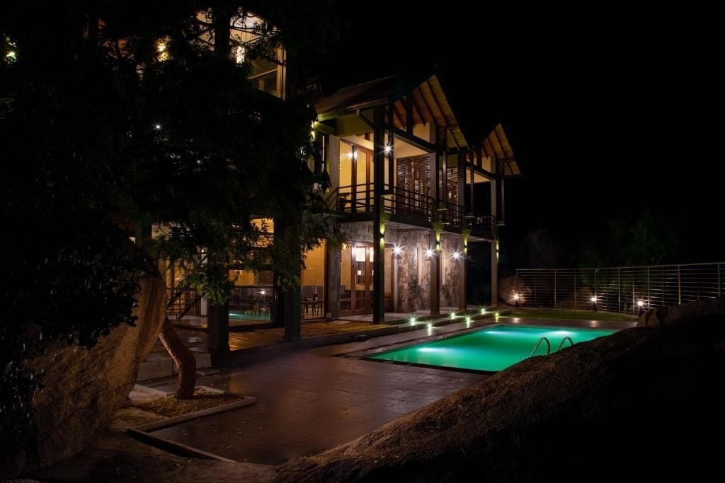 Un edificio de varios pisos con una piscina por la noche.